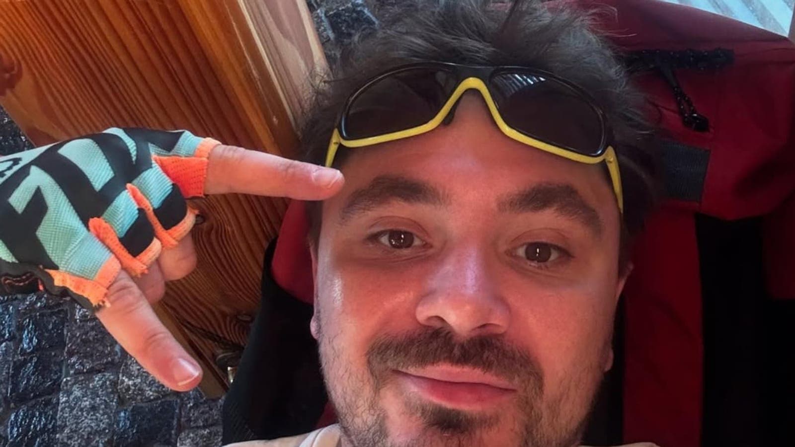 Daniel Martyniuk na selfie, z żółtymi okularami przeciwsłonecznymi na czole i rękawiczką rowerową na dłoni